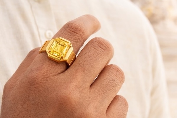 yellow sapphire ring in index finger